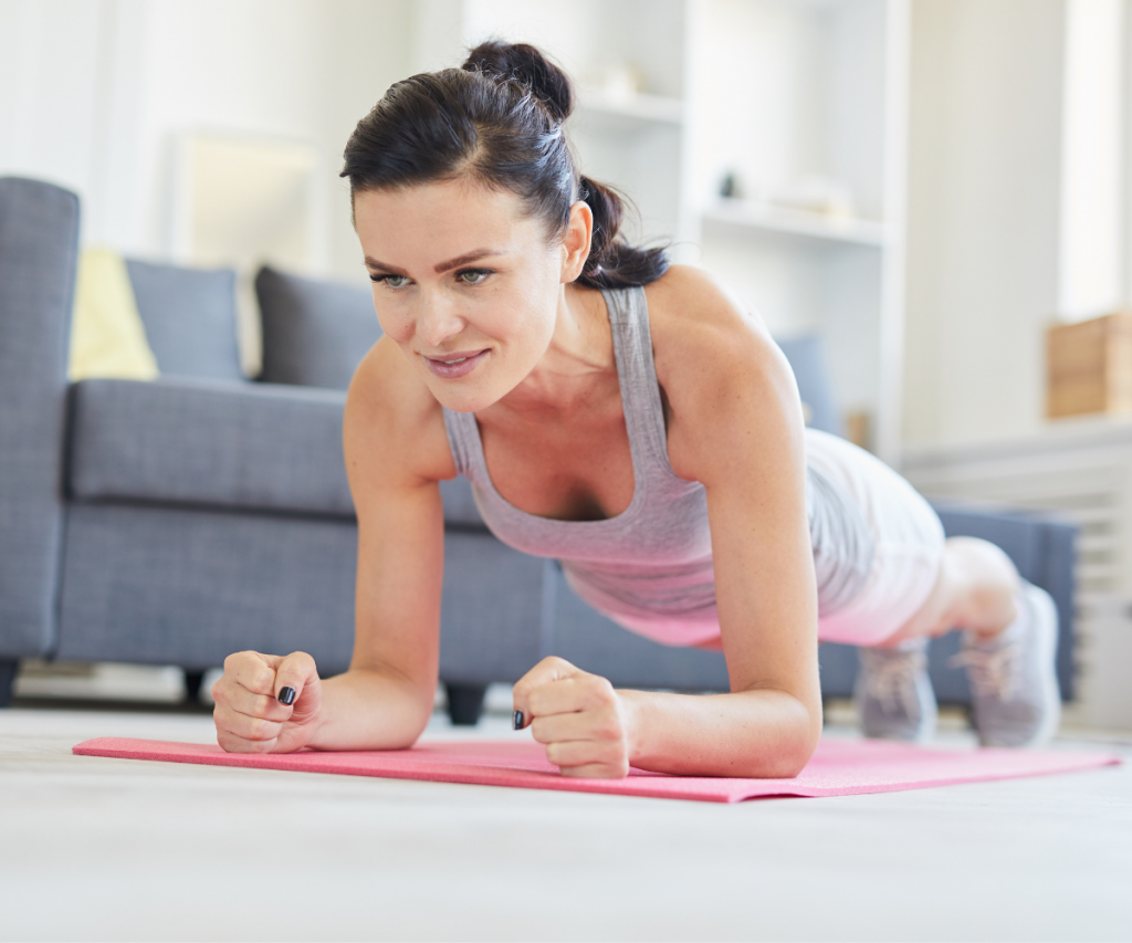 woman over 40 doing a plank in her home
