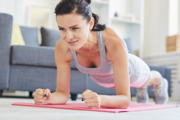 woman over 40 doing a plank in her home